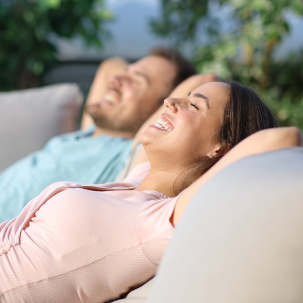 mężczyzna i kobieta leżą wygodnie, uśmiechnięci, na kanapach i odpoczywają