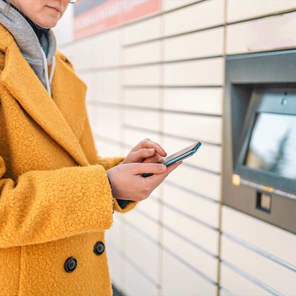 kobieta odbiera paczkę z automatu