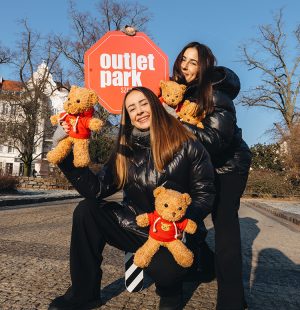 dwie kobiety z pluszakami i znakiem outlet park szczecin