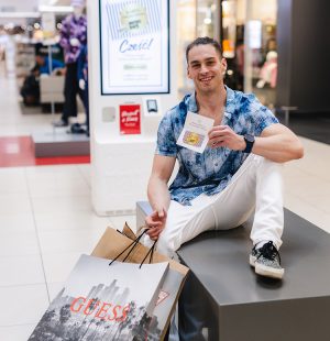 mężczyzna na zakupach w outlet park szczecin modnie ubrany w kolorową koszulę