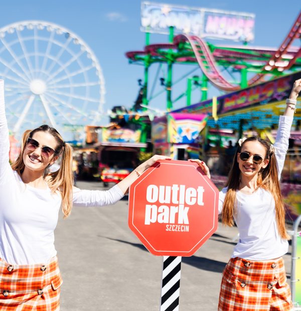 dwie kobiety opierające się o znak outlet park szczecin modnie ubrana w letni strój