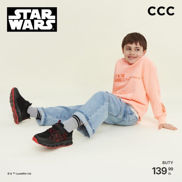 Chłopiec w bluzie i jeansach siedzi, prezentując czarne buty Star Wars z czerwonymi elementami. Logo Star Wars i CCC widoczne.
