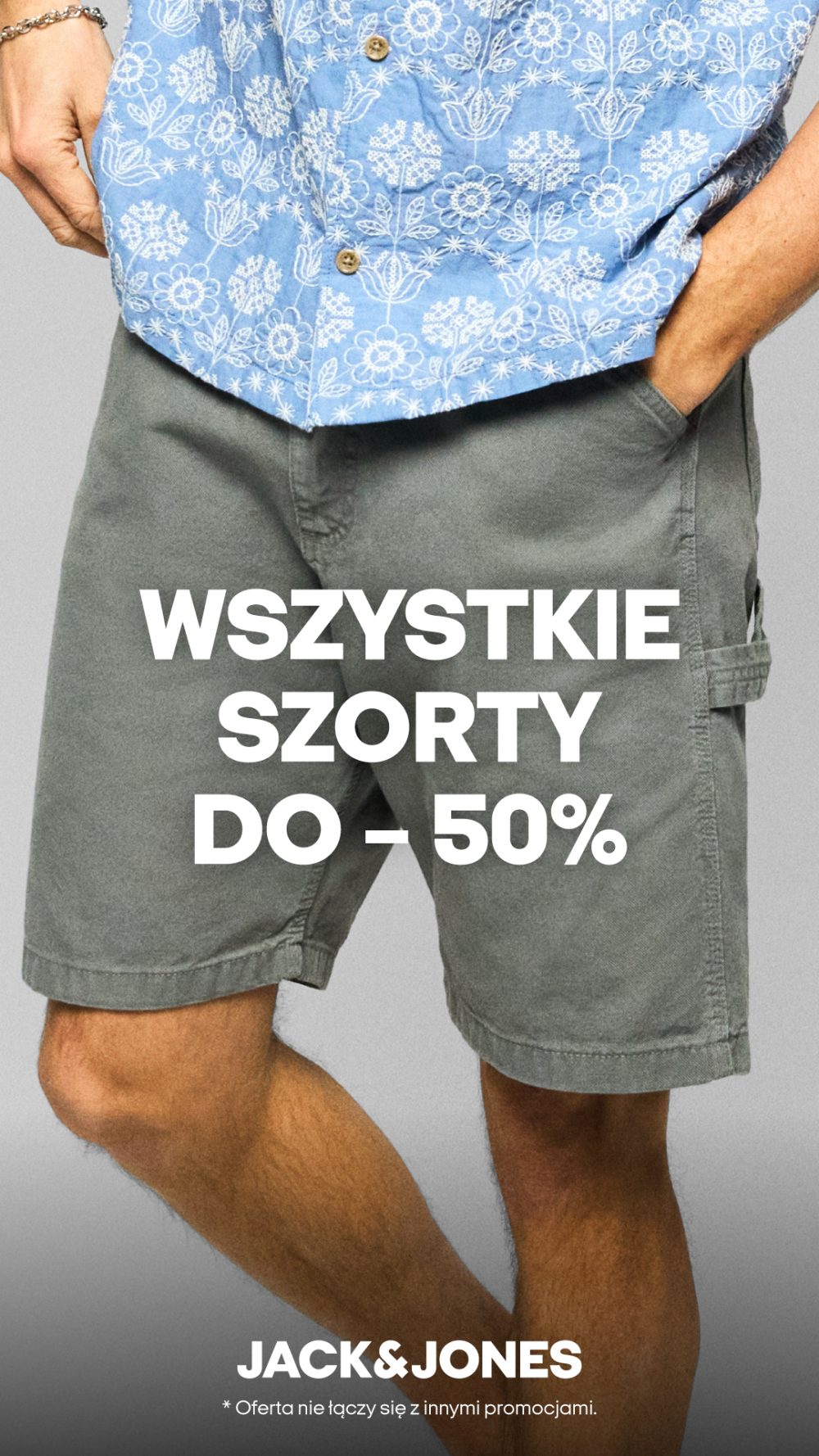 Mężczyzna w niebieskiej koszuli w kwiaty i szarych szortach, z napisem 'WSZYSTKIE SZORTY DO -50%' oraz logo Jack&Jones.