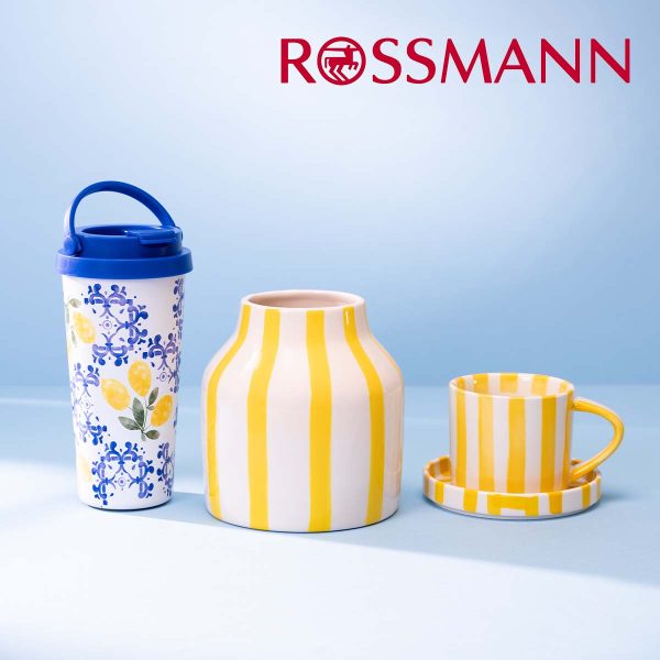 Trzy akcesoria kuchenne: kubek termiczny z cytrynami, wazon w żółte paski, filiżanka ze spodkiem w żółte paski. Logo Rossmann.