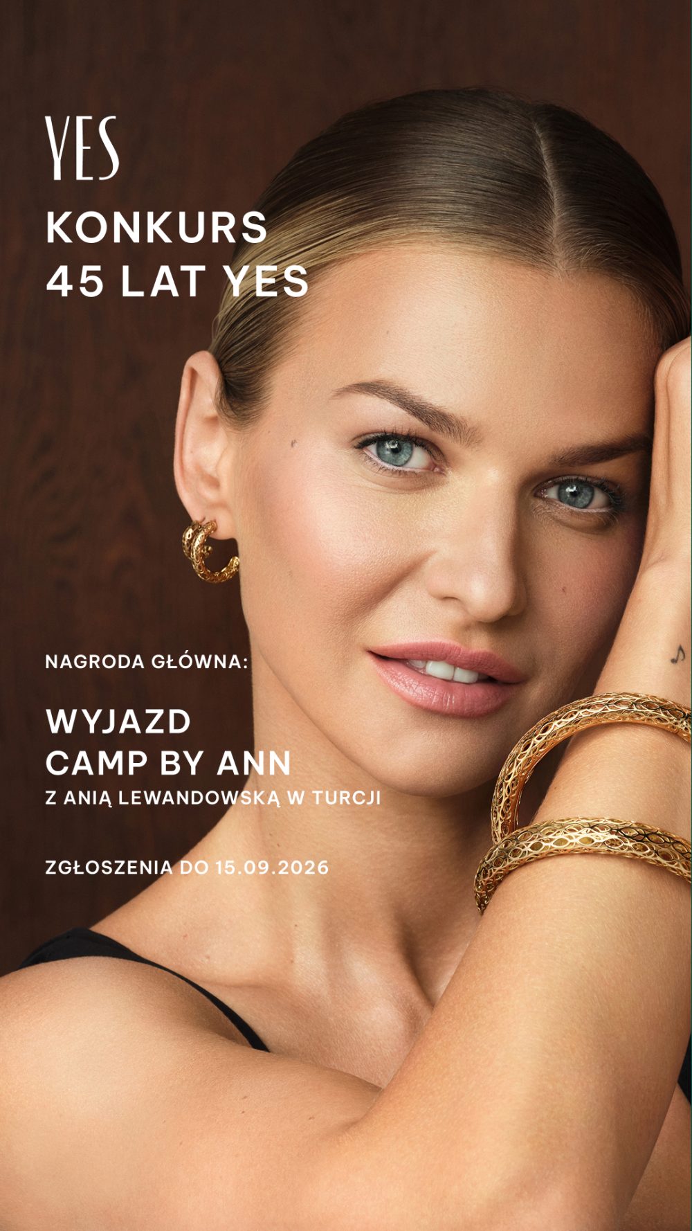 Kobieta z biżuterią YES, uśmiechnięta, z napisem 'YES KONKURS 45 LAT YES' i informacją o nagrodzie głównej 'WYJAZD CAMP BY ANN Z ANIĄ LEWANDOWSKĄ W TURCJI' oraz datą zgłoszeń.
