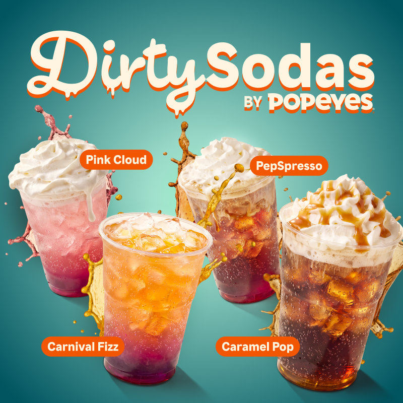 Cztery kubki z napojami Dirty Sodas od Popeyes: Pink Cloud, Carnival Fizz, PepSpresso, Caramel Pop, z bitą śmietaną i rozbryzgującymi się płynami.