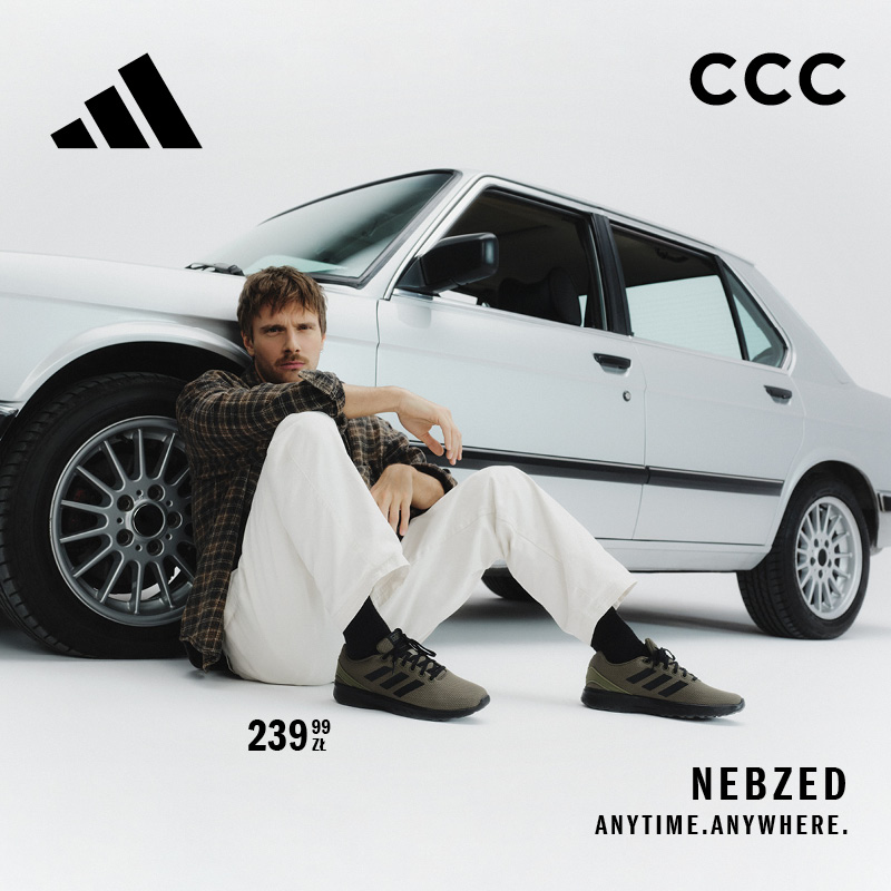 Maciej Musiał siedzi obok srebrnego samochodu, ubrany w białe spodnie, koszulę w kratę i zielone buty adidas Nebzed. W tle logo adidas i CCC.