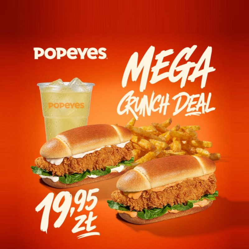 Zestaw Mega Crunch Deal z Popeyes na pomarańczowym tle, zawierający dwa sandwicze z kurczakiem, frytki i lemoniadę, z ceną 19,95 zł.