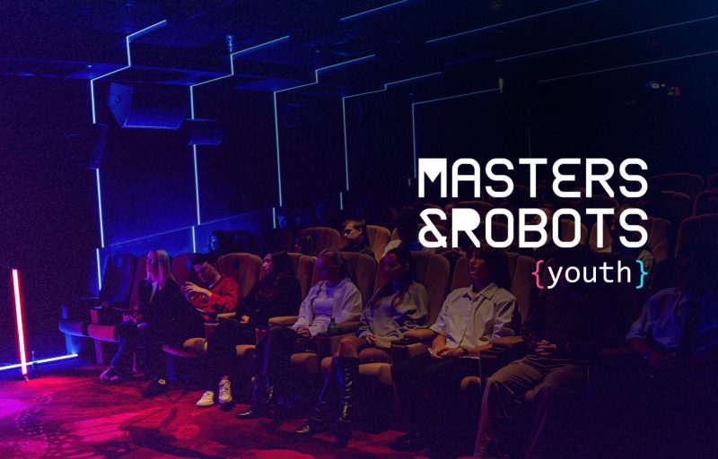 Uczestnicy konferencji Masters & Robots Youth na sali kinowej, na zdjęciu logo wydarzenia